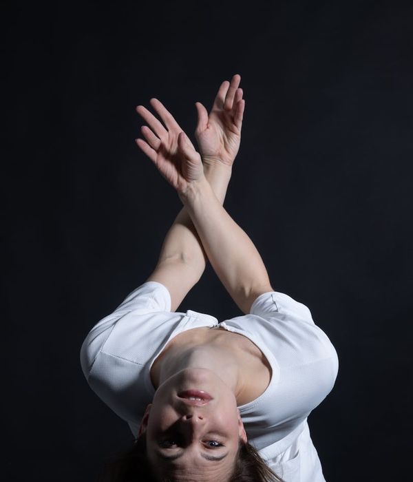 Woman performing a fluid cardio movement in a minimalist studio.